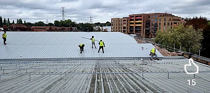 Roofing team installing metal roof sheets